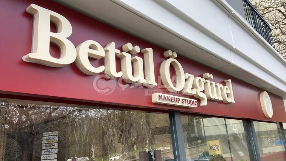 Betül Özgürel Makeup Studio cephesinde bordo zemin üzerindeki kabartma harfler