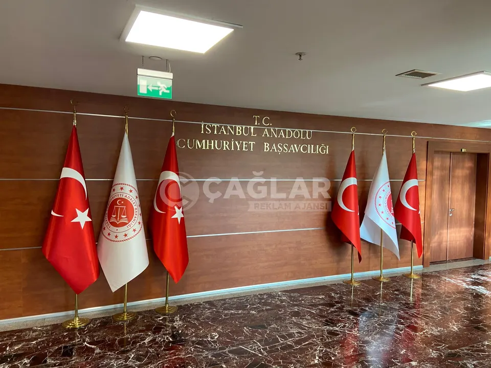 Ahşap kaplı kurumsal toplantı salonu duvarına uygulanan metal harfler