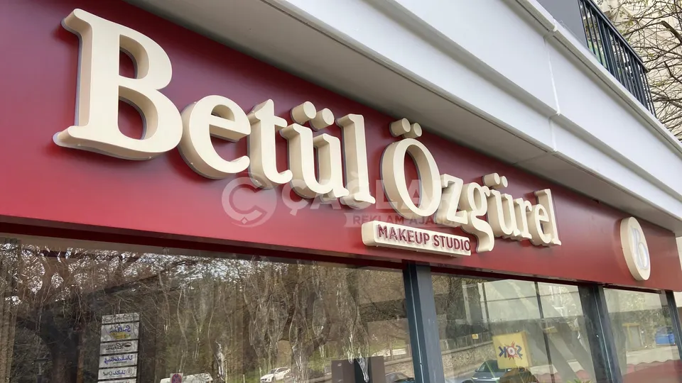 Betül Özgürel Makeup Studio cephesinde bordo zemin üzerindeki kabartma harfler