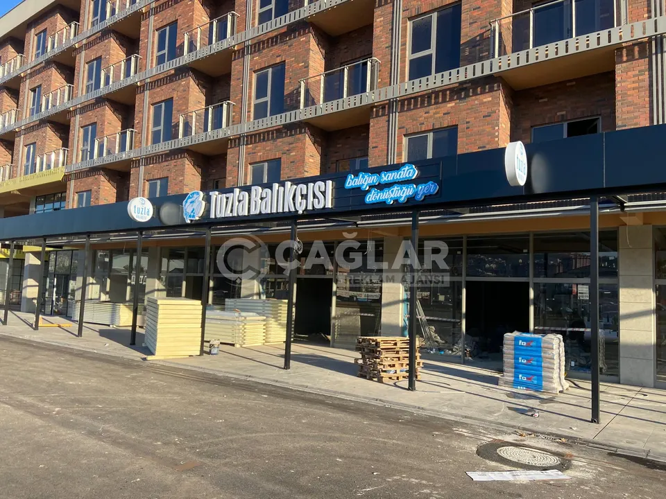 Tuzla Balıkçısı restoranının cephesi boyunca uzanan logo ve kutu harf tabela